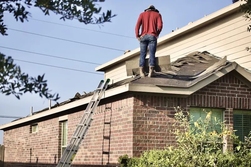 Professional roofer working on a residential roof in Village of Glen Oaks